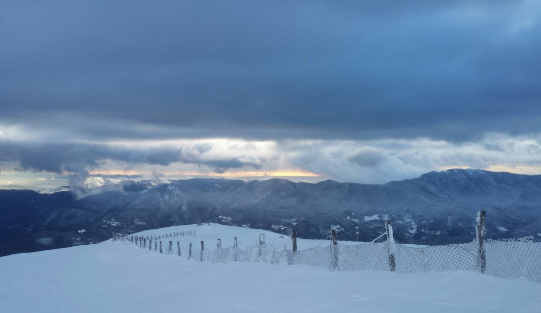 Winter scene at Doganaccia 2000 – Cutigliano in Tuscany, Italy, featuring a vibrant ski resort surrounded by snow-covered slopes, encapsulating the beauty and excitement of winter sports.