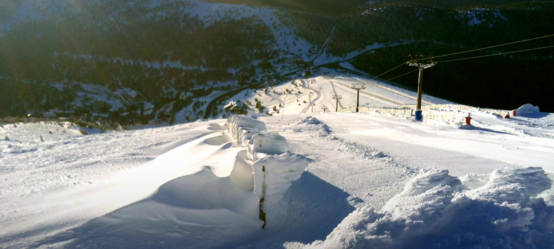 Puerto Navacerrada in Spain - a ski lift going down a snowy slope.
