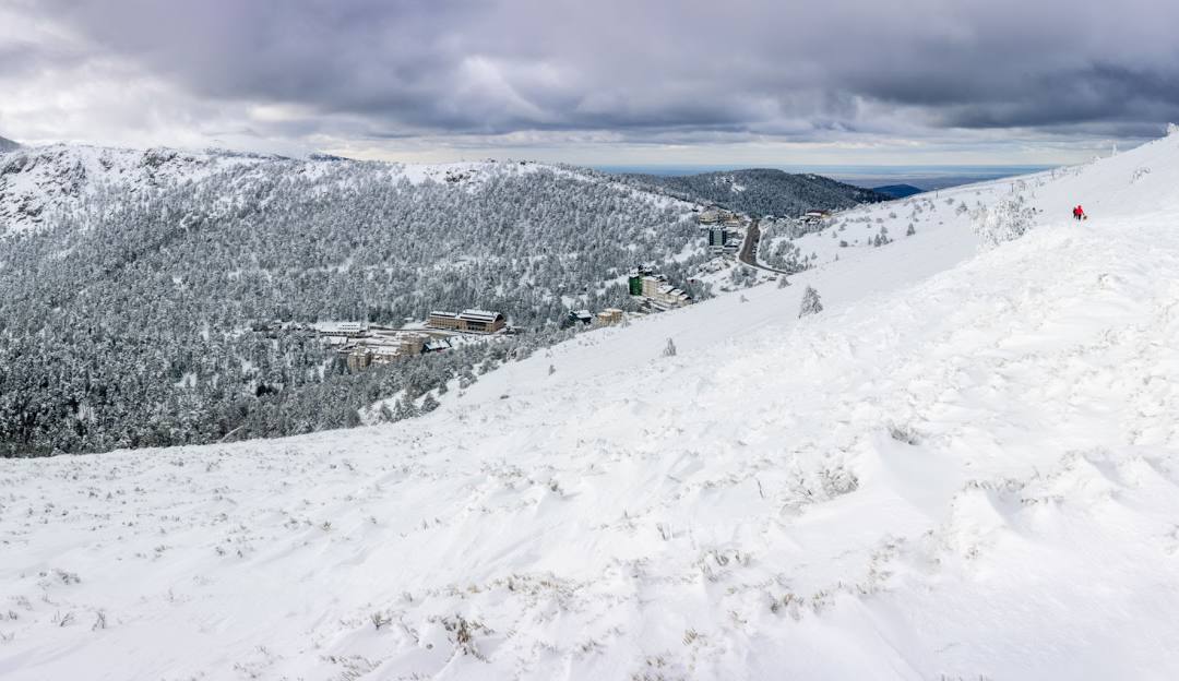 Winter sports scene at Puerto Navacerrada Ski Resort in Cercedilla, Madrid, showcasing a stunning snowy landscape with a charming chalet in the background.