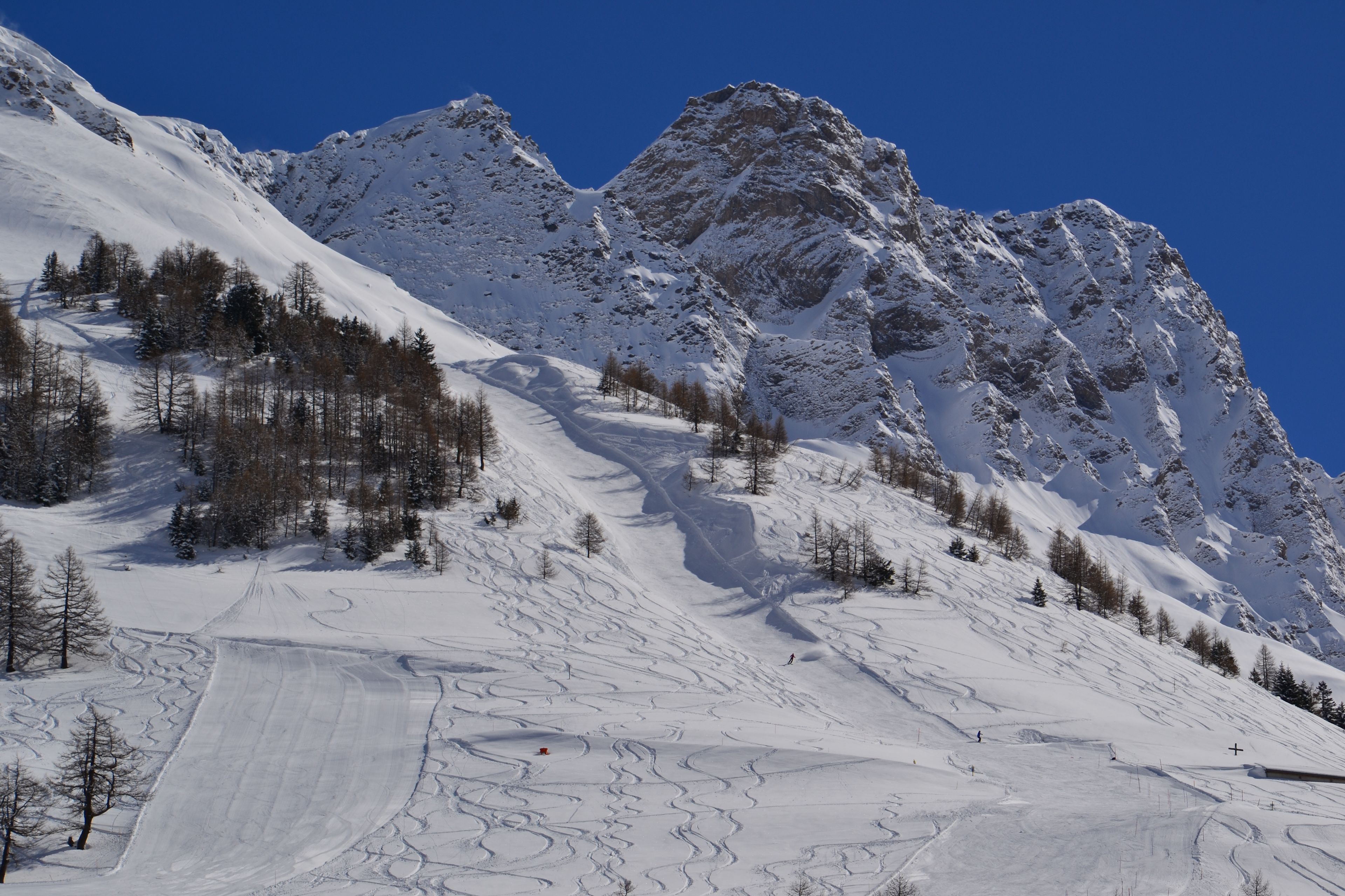 Scenic view of La Fouly in Switzerland featuring a charming chalet nestled amongst a ski resort. Snow-covered slopes and grand mountains enhance the winter sports experience.