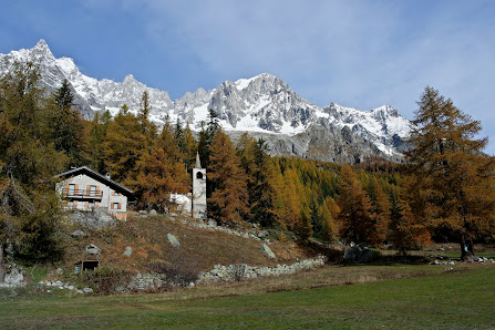 A picturesque scene of a chalet in La Fouly nestled amidst snow-blanketed mountains. This winter sports centre in Switzerland also highlights a quaint mountain hut and active ski resort.
