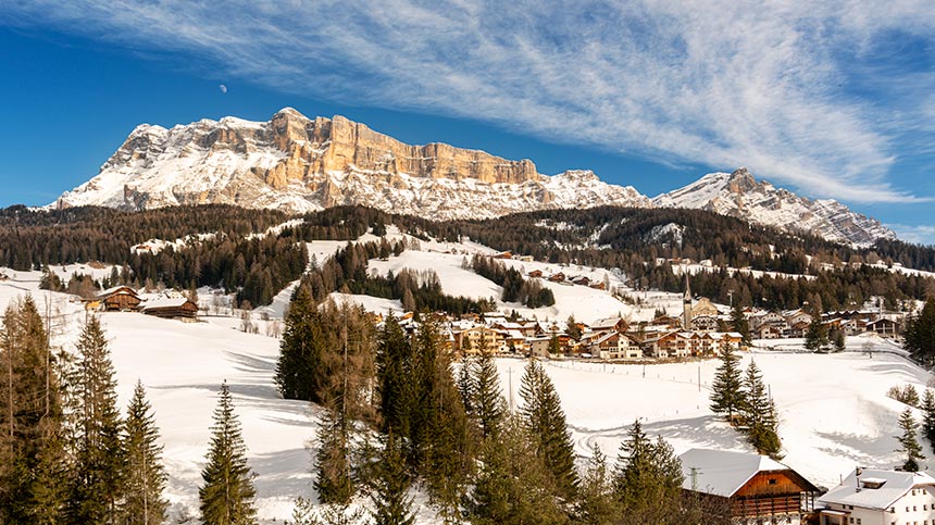 Winter scene at Alta Badia ski resort in Italy, featuring a charming chalet amidst stunning, snow-covered landscapes, popular for winter sports activities.