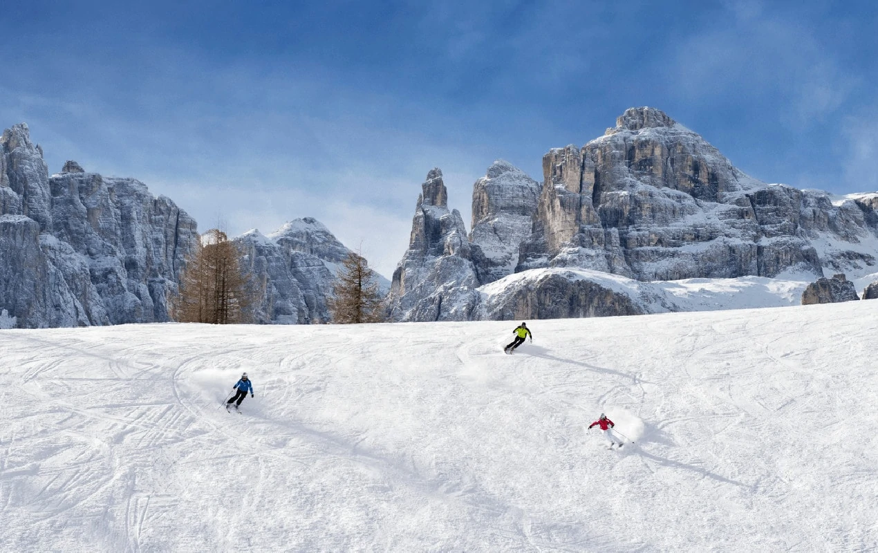 Alta Badia in Italy - a person skiing down a snow covered mountain.