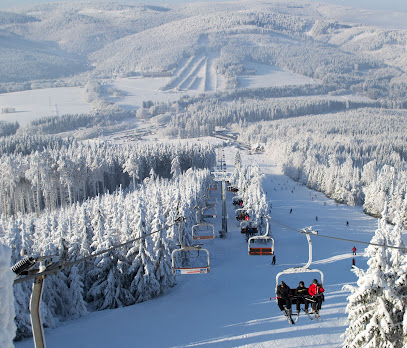 Winter scene at Bonera Ski areál Ramzová in Czech Republic, featuring a busy ski resort with ski lift on the background amidst beautiful snowy landscape.