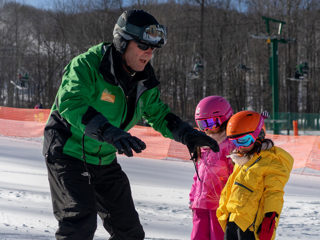 Whitetail in USA - a man teaching a little girl how to ski.