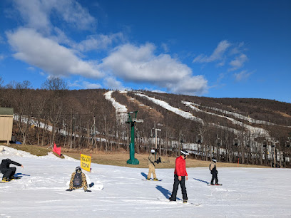 A winter sports scene at Whitetail ski resort in Mercersburg Pennsylvania featuring a ski lift transporting riders with a skier in the foreground maneuvering through the snowy terrain.