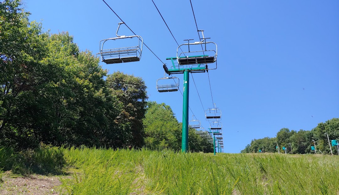A ski lift at Whitetail in Mercersburg Pennsylvania dominates the image on a cloudless day offering stunning views of the ski resort. Minimal visibility of any skier
