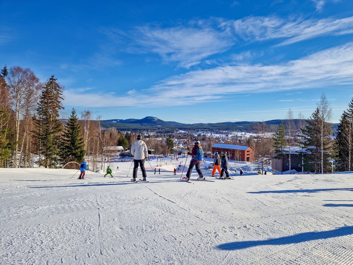 Järvsöbacken in Sweden - a group of people standing on top of a ski slope.