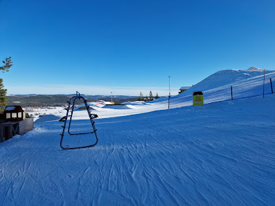 Winter scene at Järvsöbacken ski resort in Central Sweden, featuring a busy ski lift and enthusiastic skier enjoying the snowy slopes.