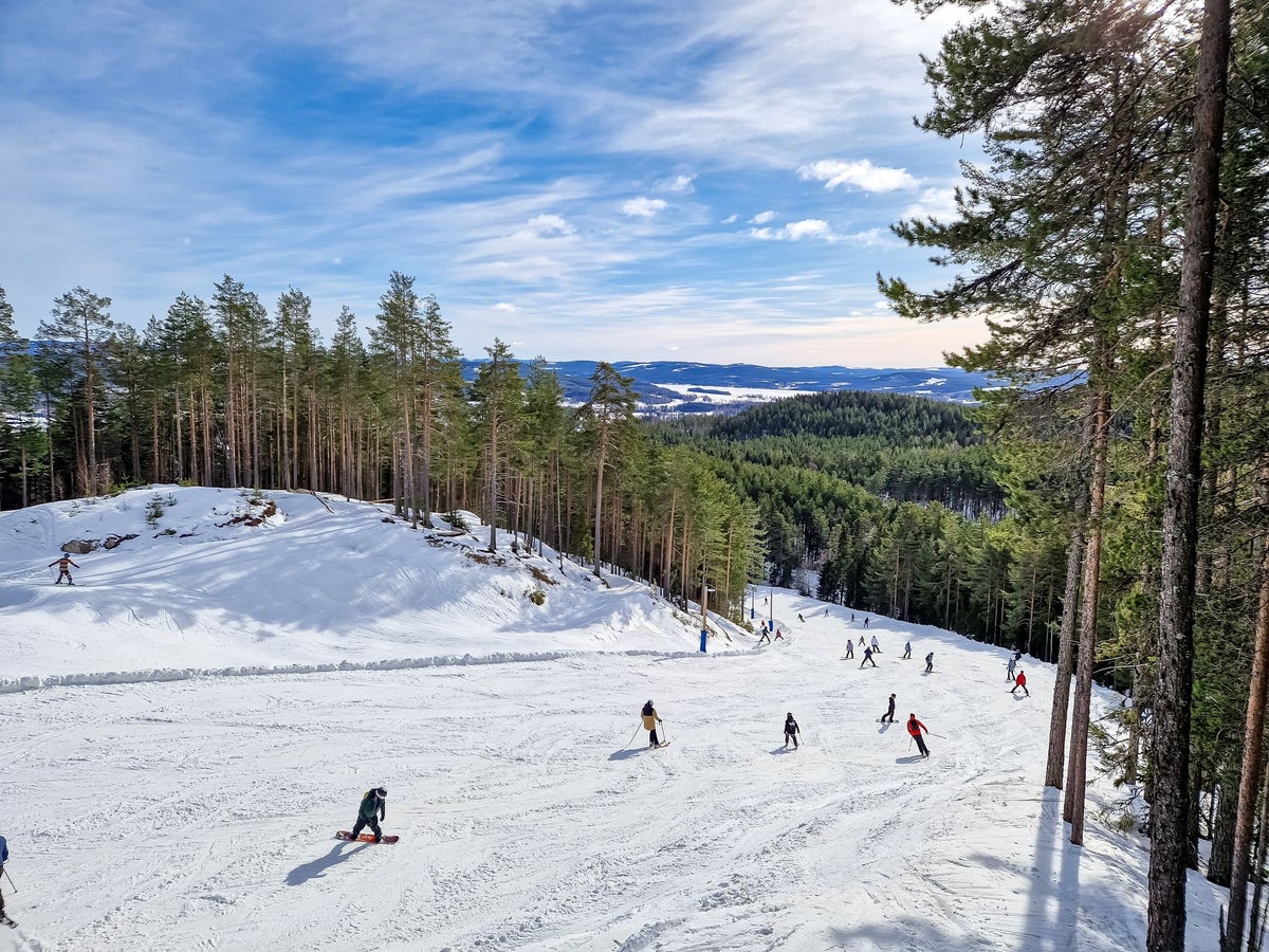 Järvsöbacken in Sweden - a group of people skiing down a snowy slope.