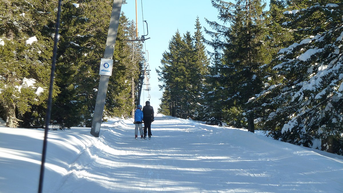 Rogla in Slovenia - a man walking down a snow covered ski slope.