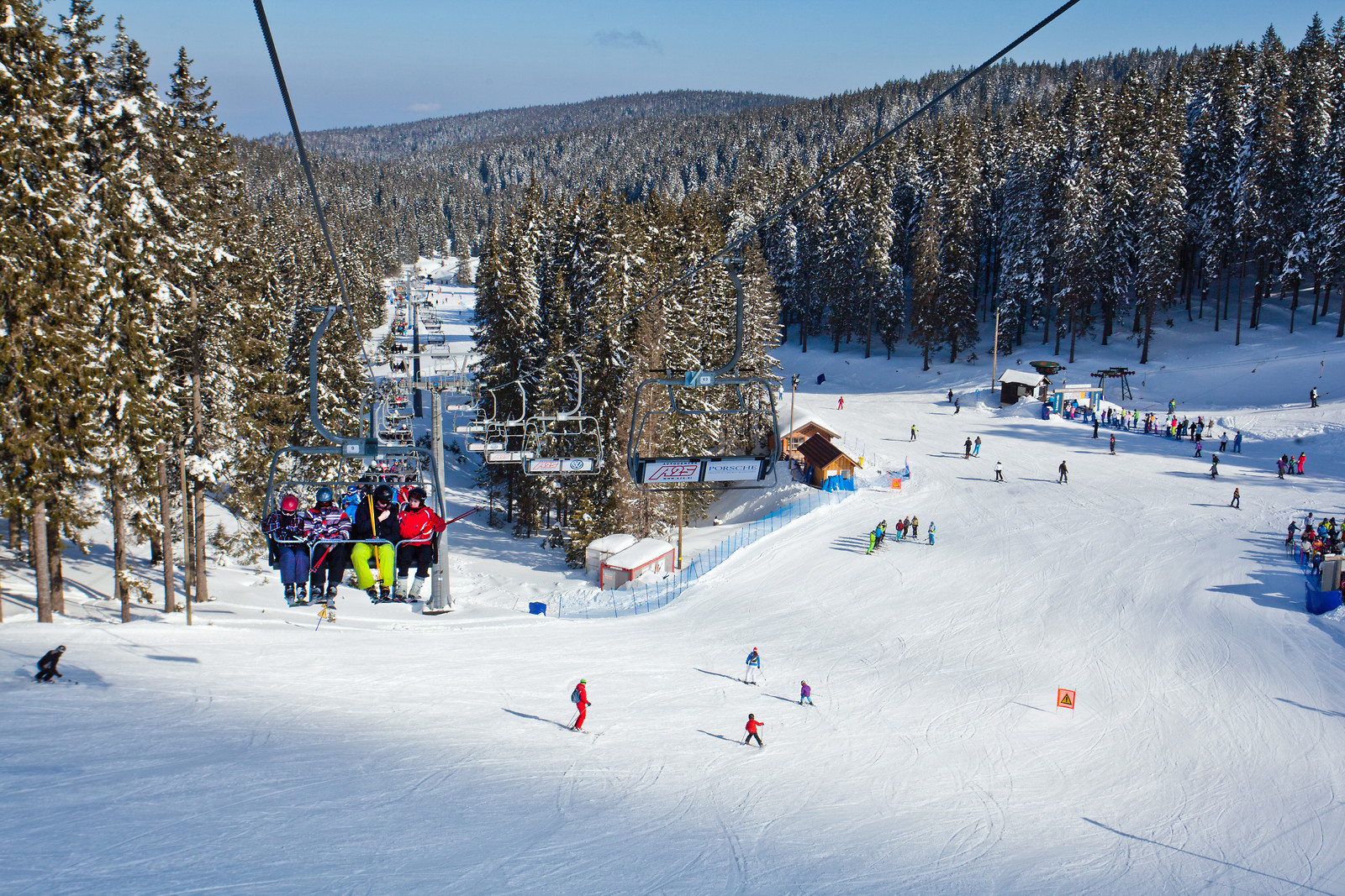 Rogla in Slovenia - a group of people skiing down a snowy slope.