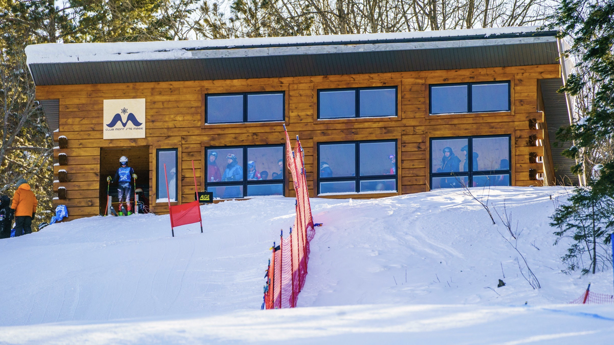 Mont Ste-Marie in Canada - a group of people standing outside of a ski lodge.