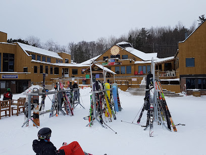 A bustling ski resort at Mont Ste-Marie in Quebec, Canada featuring active skiers on the snowy slopes, with a prominent ski lift in the backdrop.