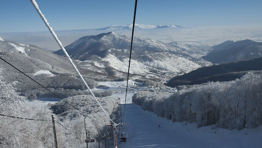 Image showcasing the breathtaking winter scenery at the Vigla Pisoderi ski resort in Verno, Greece, with a ski lift and a cozy chalet amidst the snow-dusted landscape.