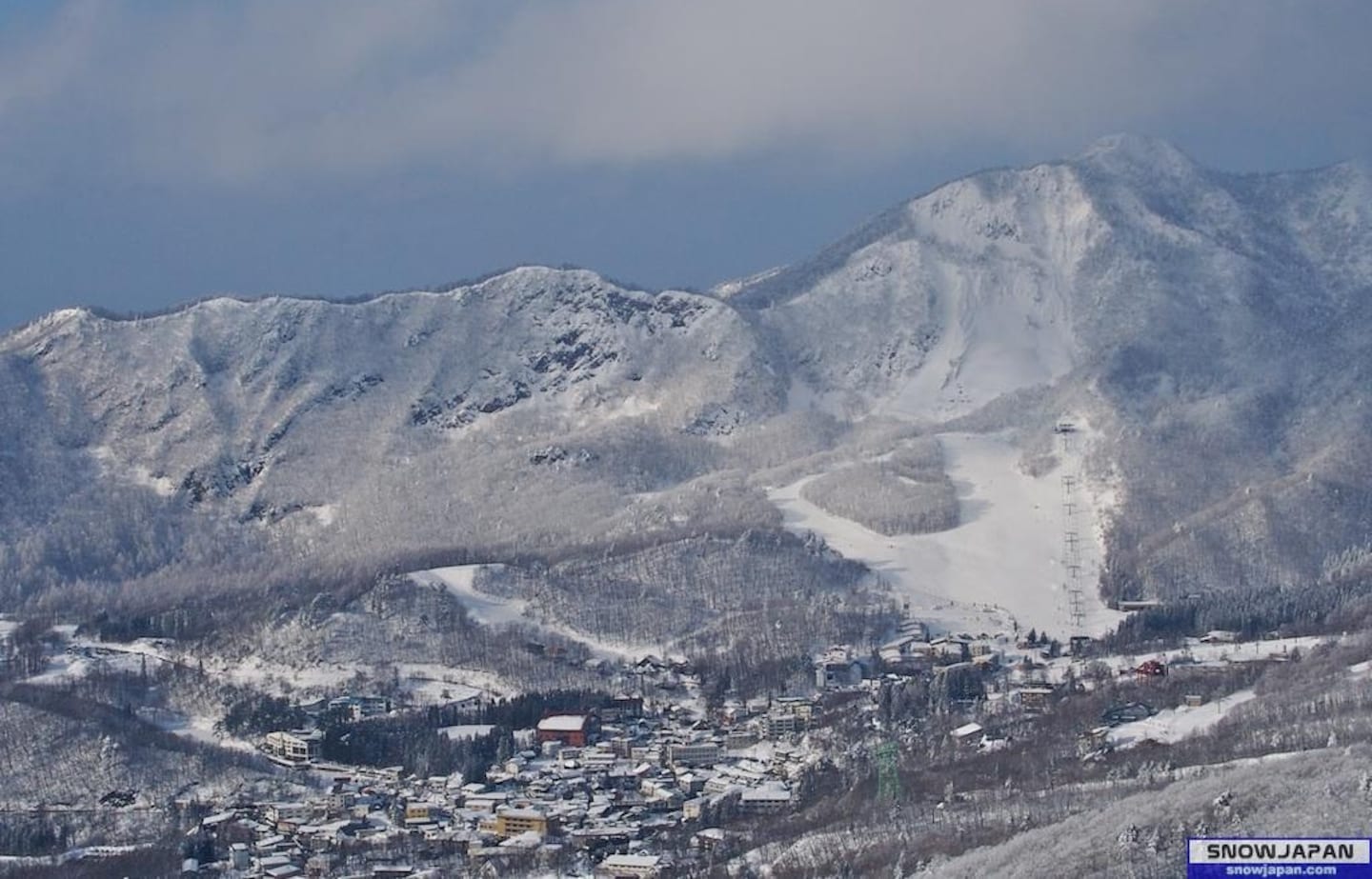 Tengendai in Japan - a snow covered mountain with a town in the background.