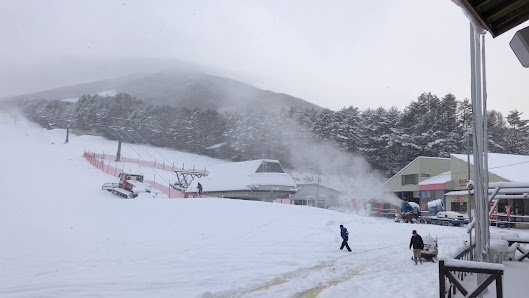 Winter scene at Hida Funayama Snow Resort Arkopia in Japan, featuring bustling activity at the winter sports centre, amidst the stunning backdrop of snow-laden slopes and pristine ski trails.