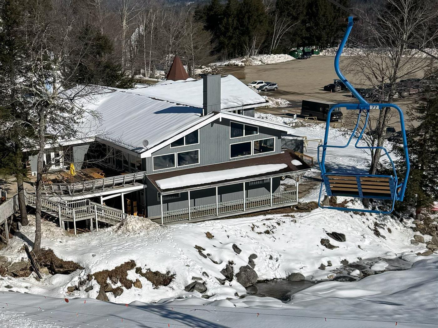 Tenney Mountain in USA - a house with snow on the ground and a ski lift.