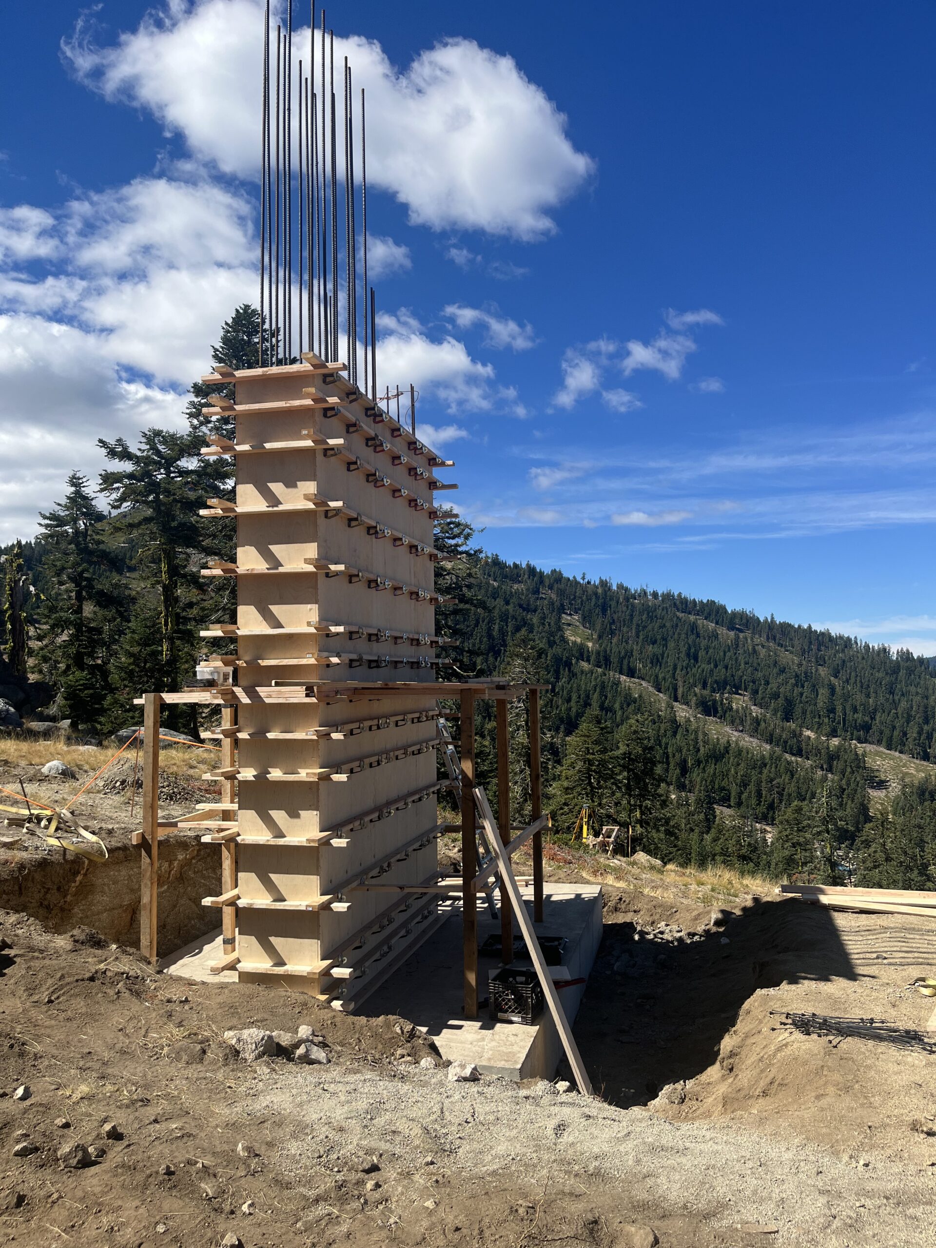View of Mt. Ashland on a sunny day, featuring a chalet and lodge nestled into the mountain landscape. A ski lift stands ready to carry skiers to the top of the slope.