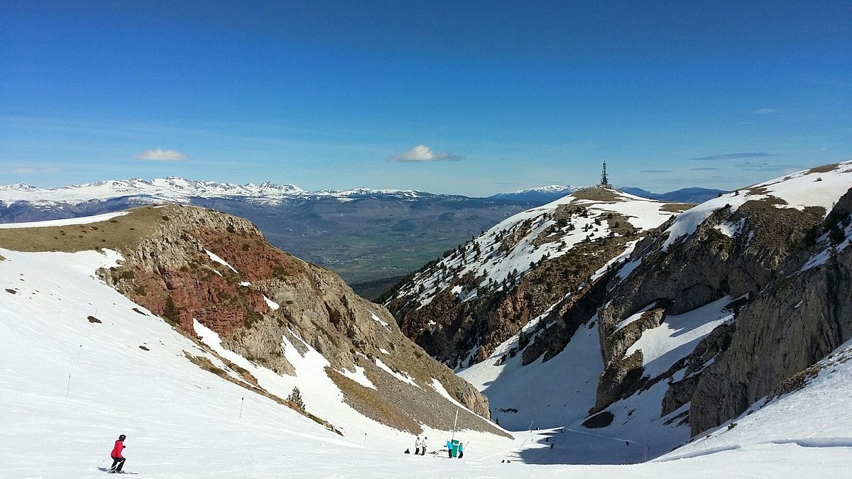 Muntanya de Masella in Spain - a group of people skiing down a snowy mountain.