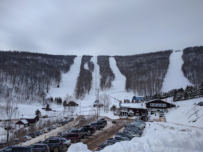 View of the popular Plattekill Ski Resort in Roxbury New York featuring a ski lift and snow-covered slopes set against a rugged mountain backdrop. Winter sports enthusiasts can be seen enjoying the area.