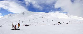 Ski chalet overlooking snow-covered slopes in Hlíðarfjall, Akureyri, Iceland. Scene captures the essence of a bustling ski resort and winter sports centre.