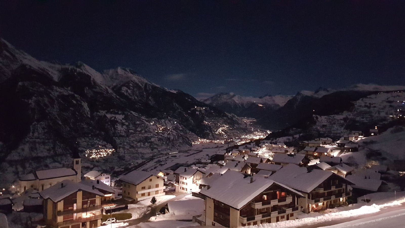 Sportbahnen Eischoll Augstbordregion in Switzerland - a view of a snowy town at night.