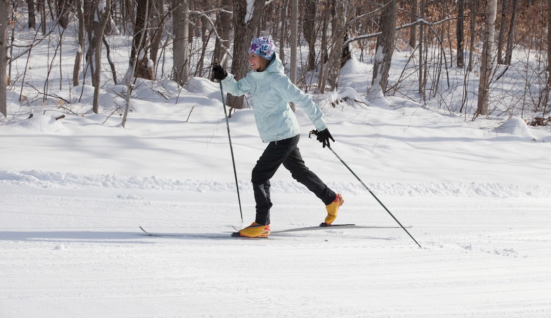 A skier carefully traversing down the slopes at Black Mountain of Maine in Rumford, amidst a winter sports scene.