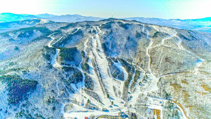 View of Black Mountain ski resort in Rumford, Maine showcasing a stunning winter scenery with snow-covered slopes and a ski lift. The scene epitomizes an idyllic winter sports destination.