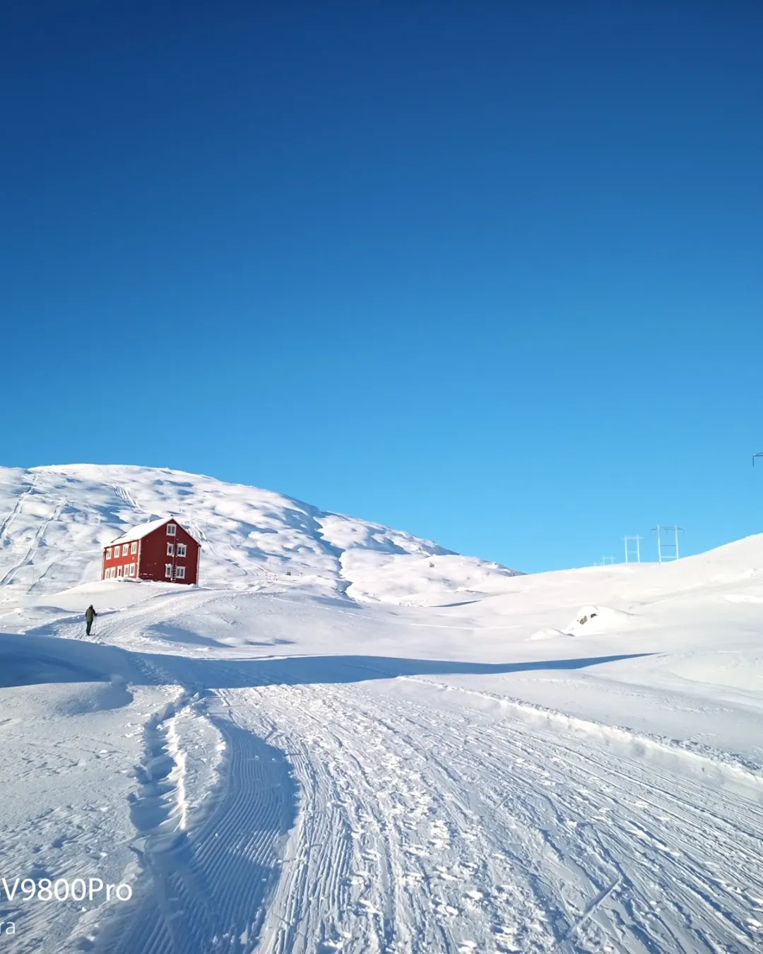 Røldal in Norway - a red house sits on top of a snowy hill.