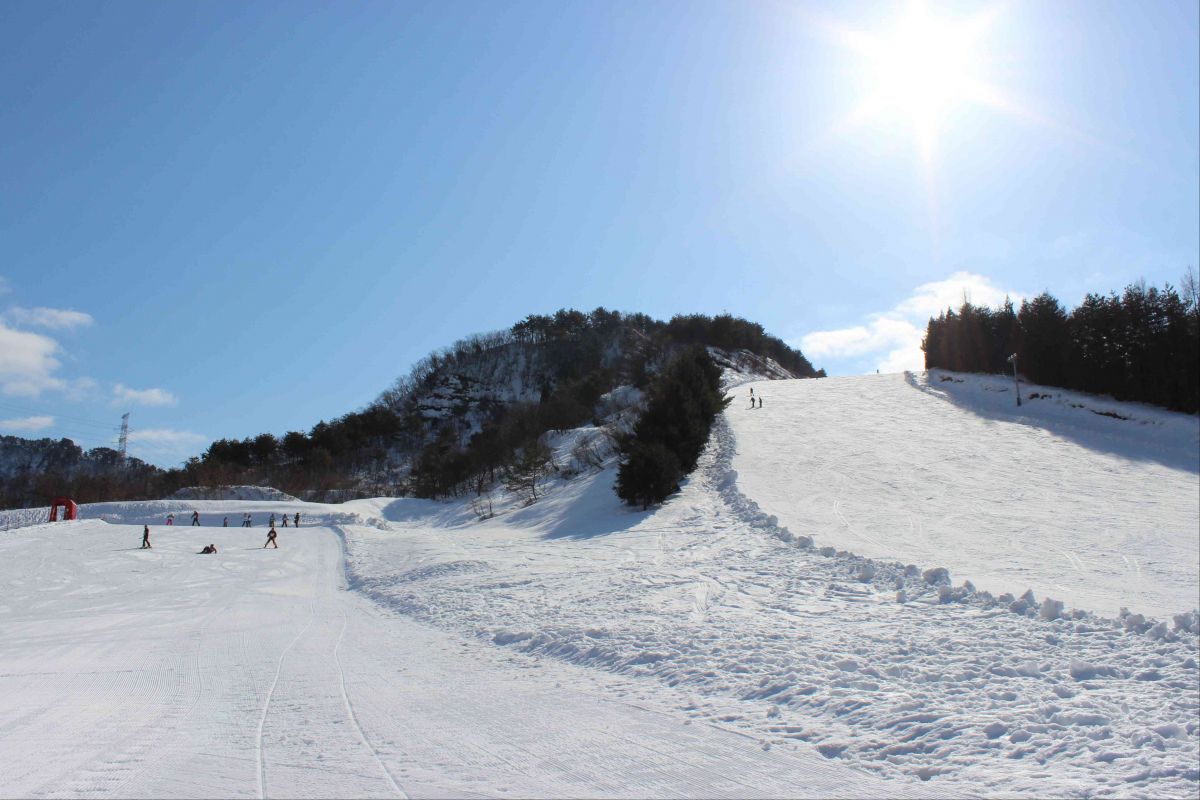 Tainai in Japan - a ski slope with people skiing down it.