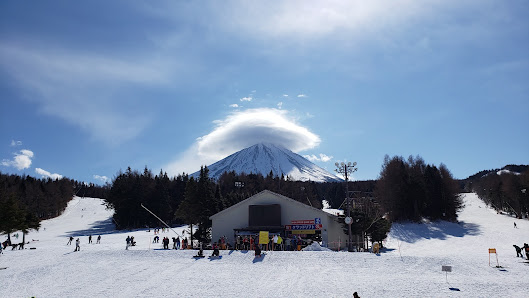 A picturesque view from Fujiten Snow Resort in Japan, showcasing a majestic snow-covered mountain, vibrant winter sports scenes, amid tranquil winter scenery.