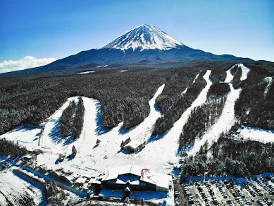 View of Fujiten Snow Resort in Japan, showcasing a bustling winter sports scene. The image features a ski resort nestled in snow-clad mountains with beautifully maintained slopes.