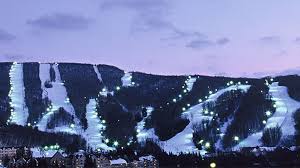 A picturesque view of Jiminy Peak ski resort in Massachusetts USA. The scene captures a winter sports backdrop with a ski lift ascending the snow-covered mountain amid stunning winter scenery.