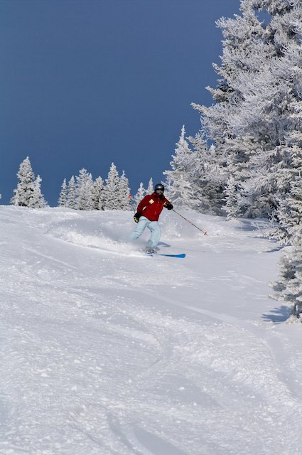 A skier carving down the pristine slopes of Murray Ridge in Fort St James British Columbia Canada. The ski resort complete with ski lift and chalet