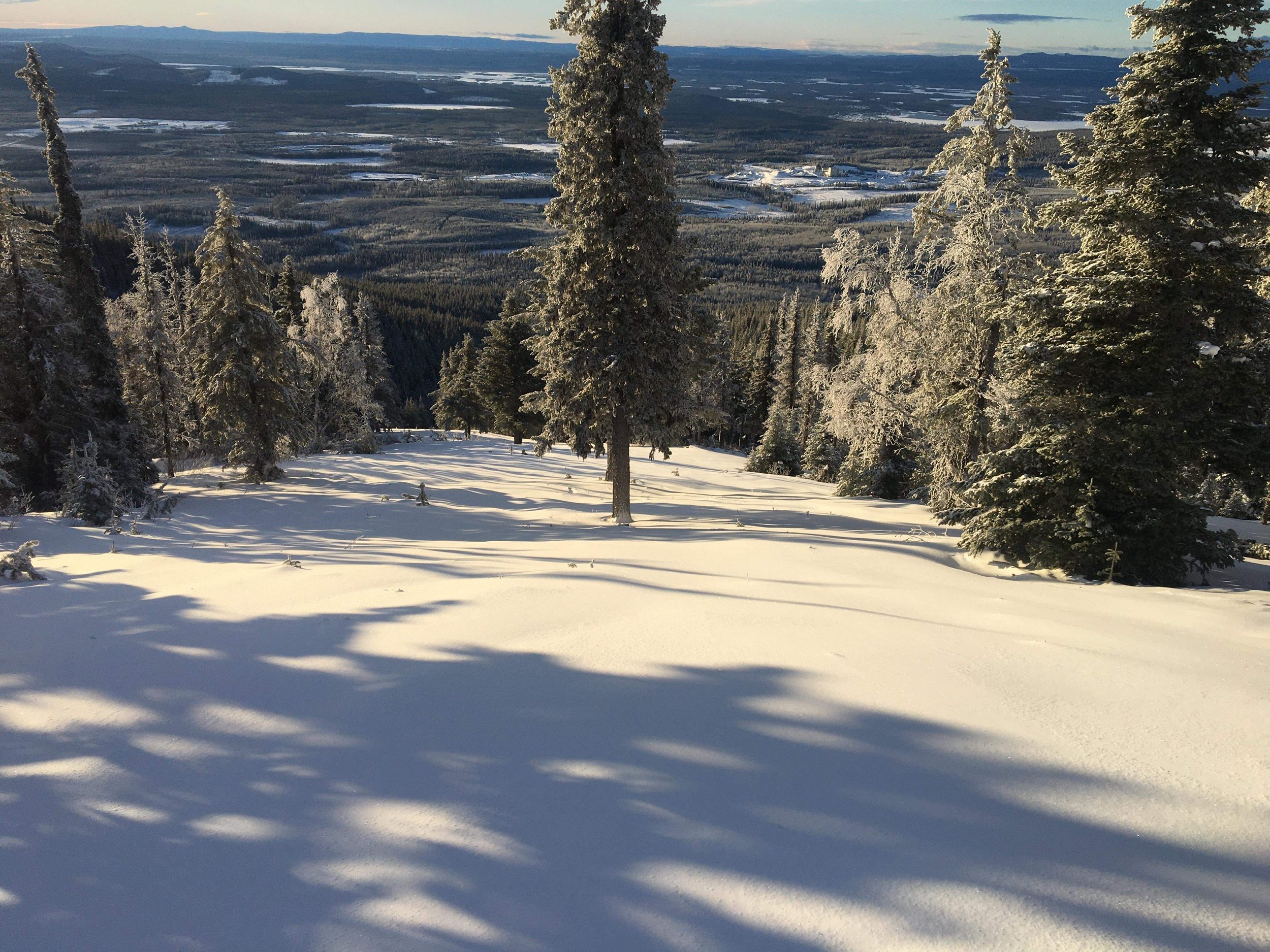 A winter sports scene at Murray Ridge in British Columbia, Canada featuring a popular ski resort. High mountains with snow-covered slopes dominate the winter landscape.