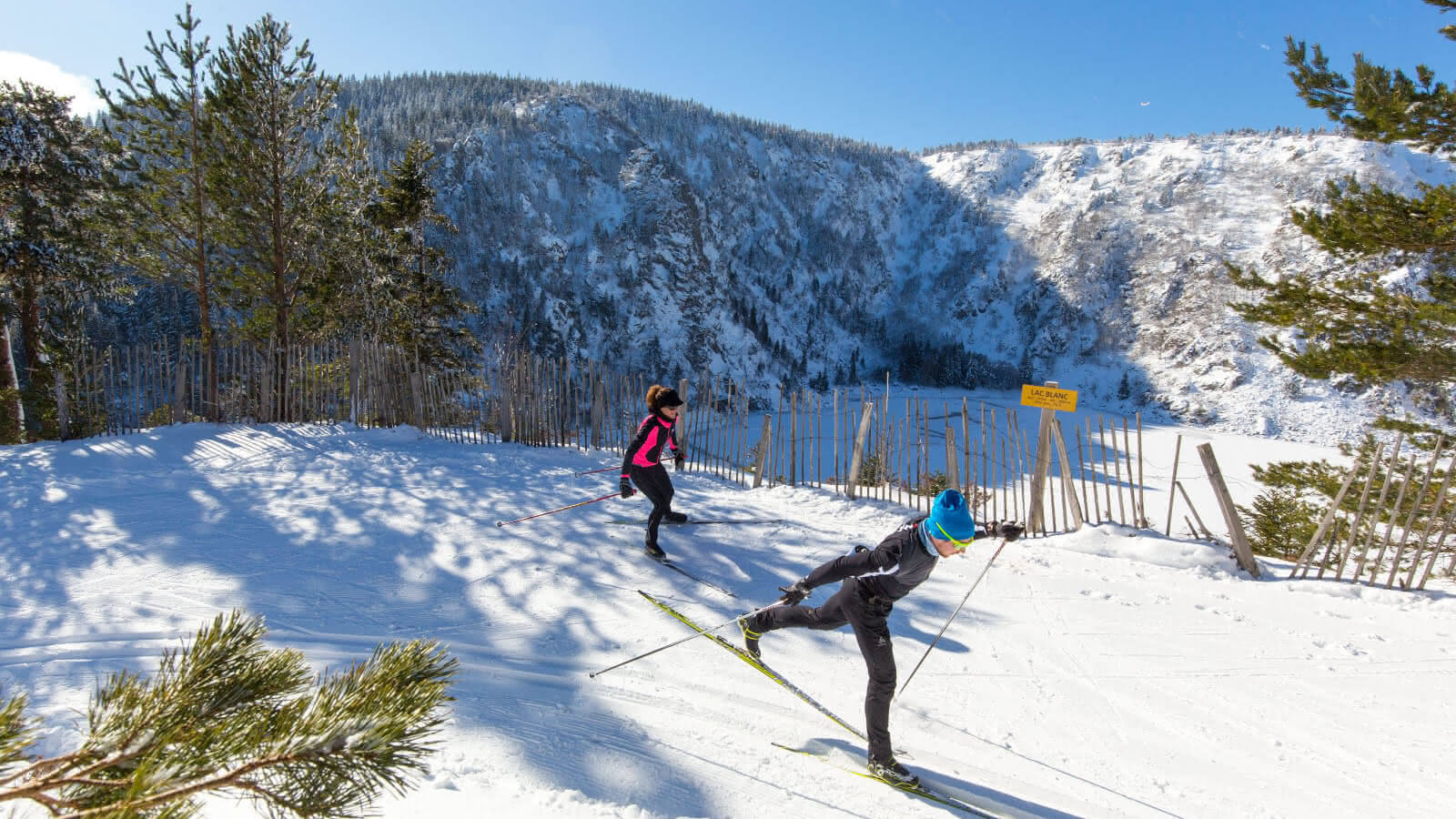 Lac Blanc in France - two people are skiing down a snowy hill.