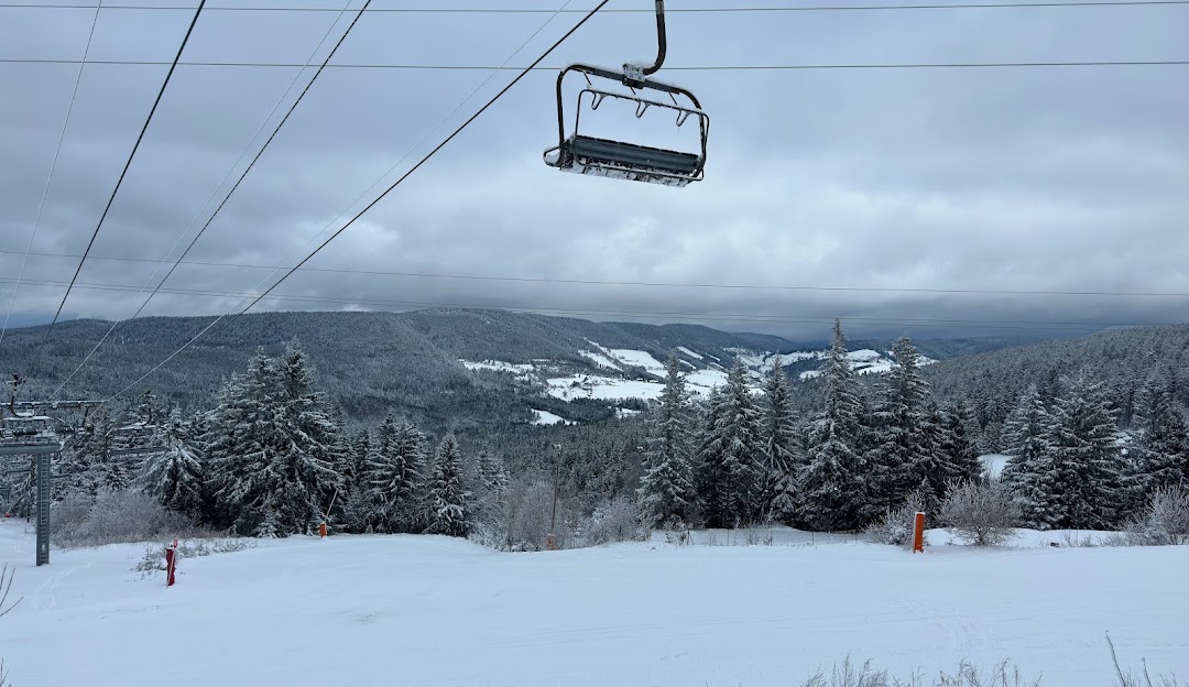 A winter scene at Lac Blanc in France with a ski lift and resort snow-covered slopes and a chalet in the background illustrating a picturesque winter sports setting.