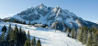 Winter sports scene at Serlesbahnen Mieders Bergbahn Bergstation in Innsbruck, Mieders, Tyrol, Austria, featuring a bustling ski resort, a cosy challet and scenic snowy landscapes.