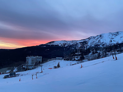 View of a ski resort in Les Monts d'Olmes, France showcasing a chalet and ski lift against a stunning winter scenery, signifying an active winter sports scene.