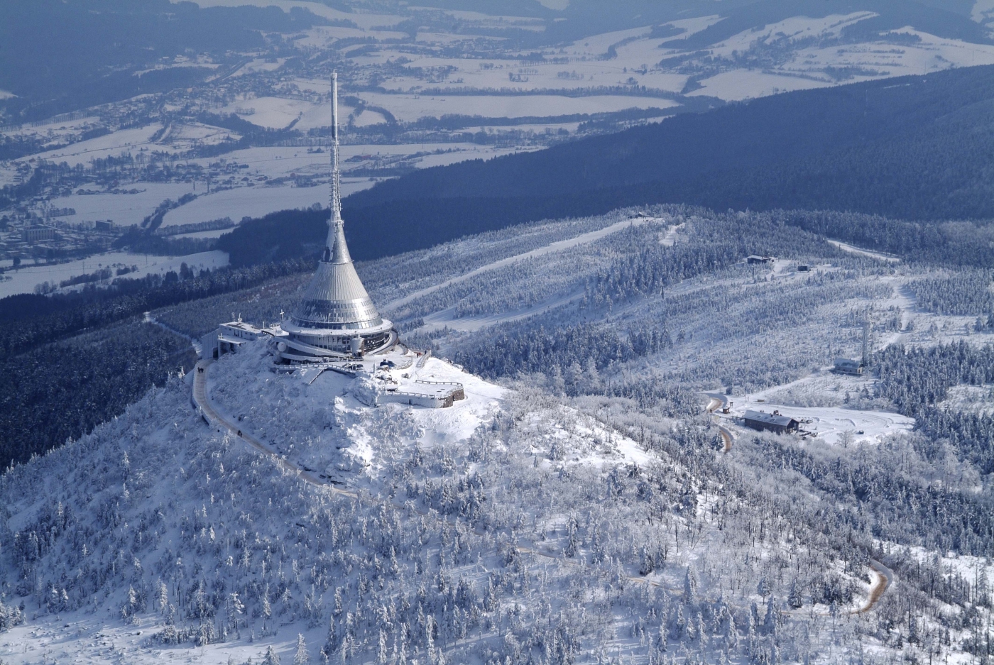 Ještěd – Liberec in Czech Republic - a plane is flying over a snowy landscape.