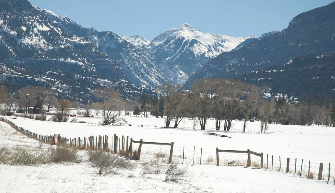 A picturesque winter scene at Mt Abram in Maine, USA. Visible is a charming chalet nestled amongst the snow-dusted trees, with a backdrop of the mountains, hosting winter sports enthusiasts.