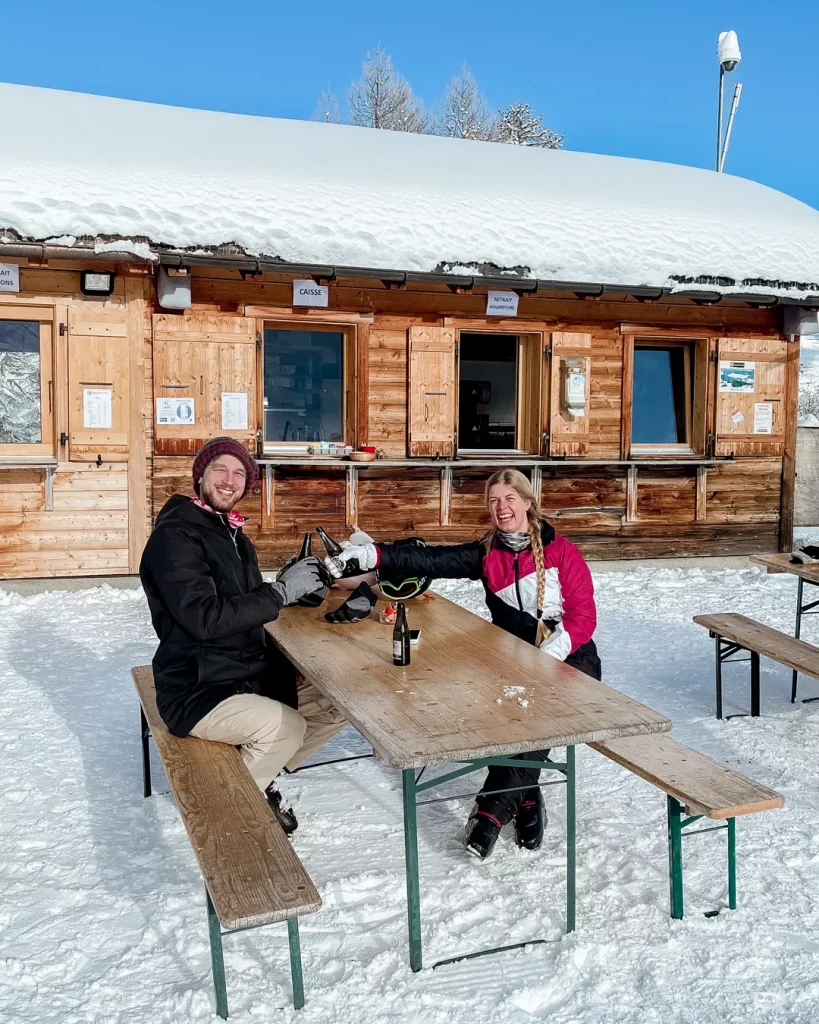 Vichères in Switzerland - two people sitting at a picnic table in the snow.