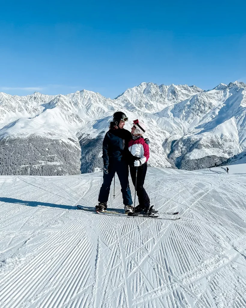Vichères in Switzerland - a man and woman standing on top of a snow covered slope.