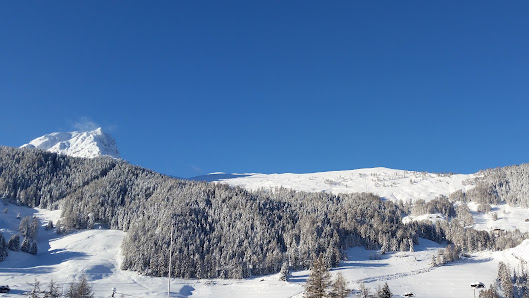 A picturesque Swiss chalet nestled in the Vichères ski resort of Valais, framed by majestic mountains. The winter sports scene and stunning winter scenery evoke a serene and inviting atmosphere.
