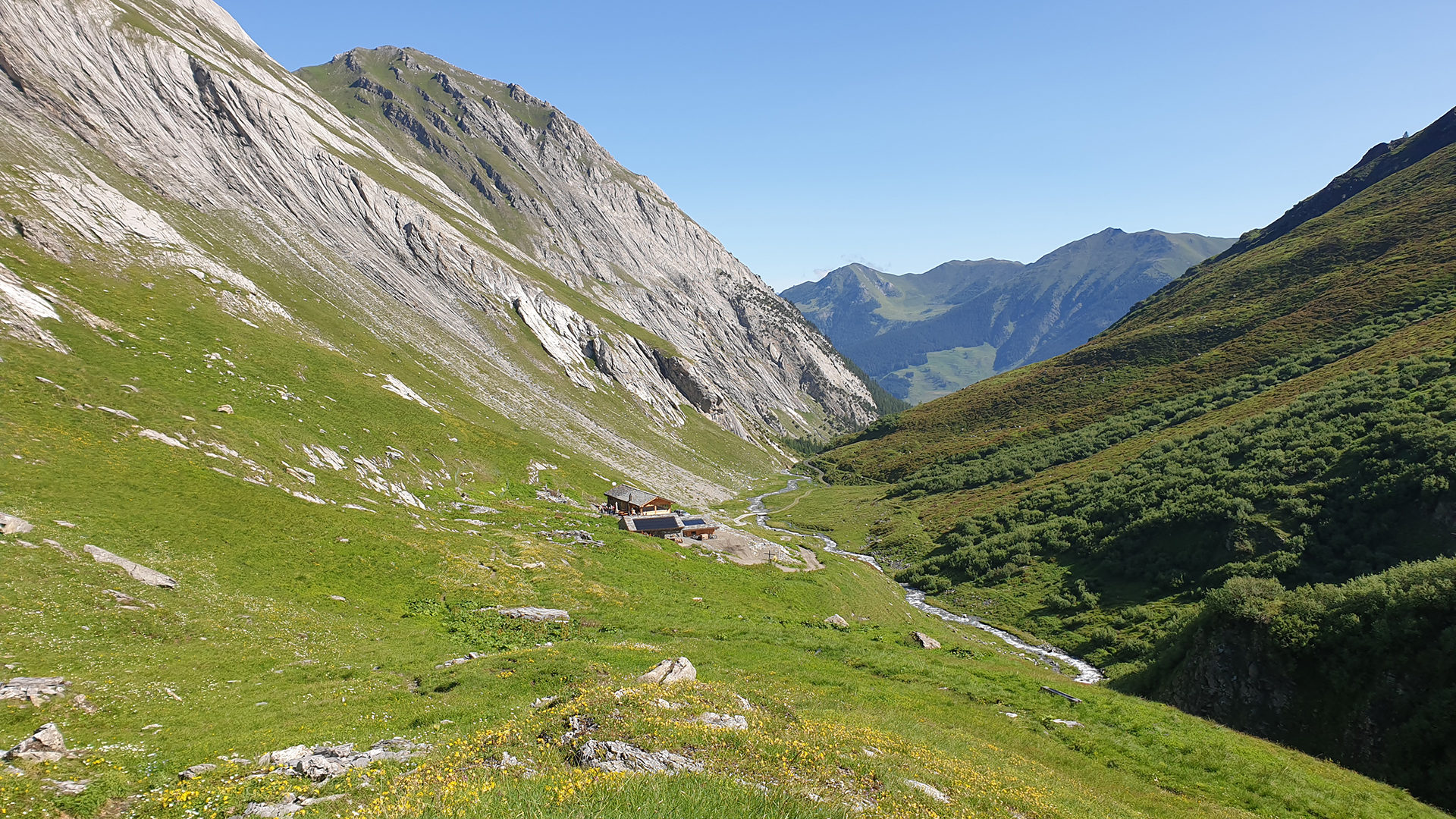 A charming chalet and mountain hut nestled against the backdrop of a soaring mountain in Vichères, Switzerland. The image also alludes to a nearby ski resort and lodge.