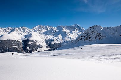 A chalet overlooks a winter sports scene at the Vichères ski resort in Switzerland, featuring skiers enjoying the snow-covered slopes.