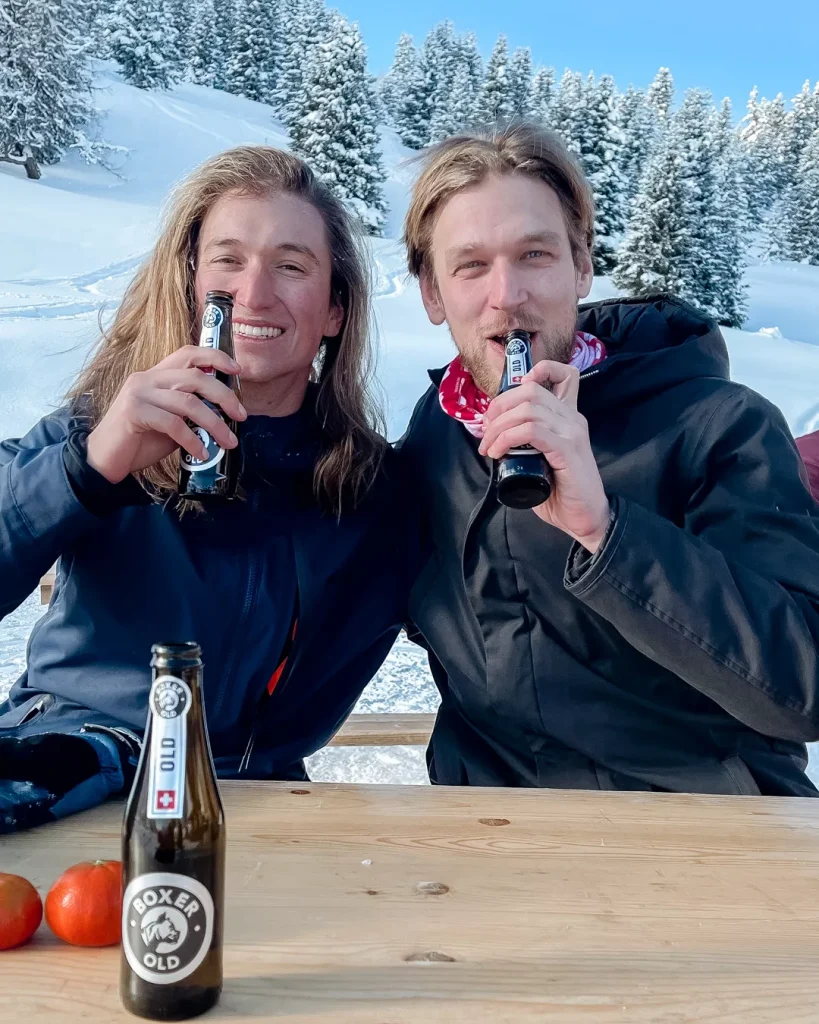 Vichères in Switzerland - two people sitting at a table with a bottle of beer.