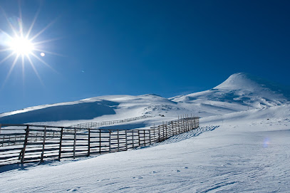 Winter sports scene in Osorno, Puerto Varas, Chile, featuring stunning winter scenery with a chalet and a winter sports centre among snow-covered landscape.