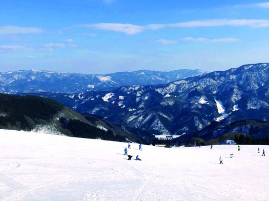 Ojiro in Japan - a group of people skiing down a snow covered mountain.
